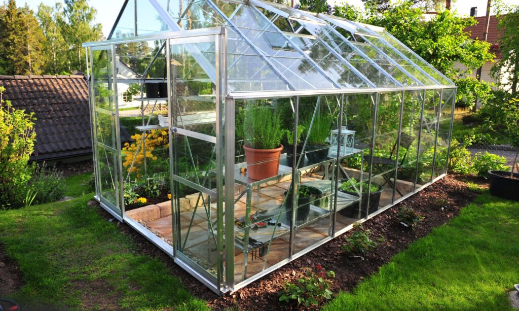 Ein Glasgewächshaus in einem Garten.